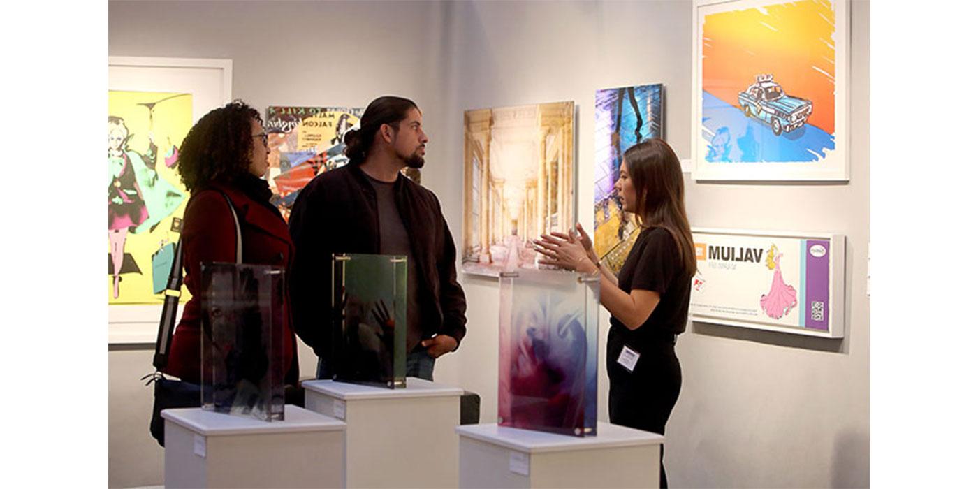 参加活动的人在波士顿国际美术展览会上与艺术专家交谈