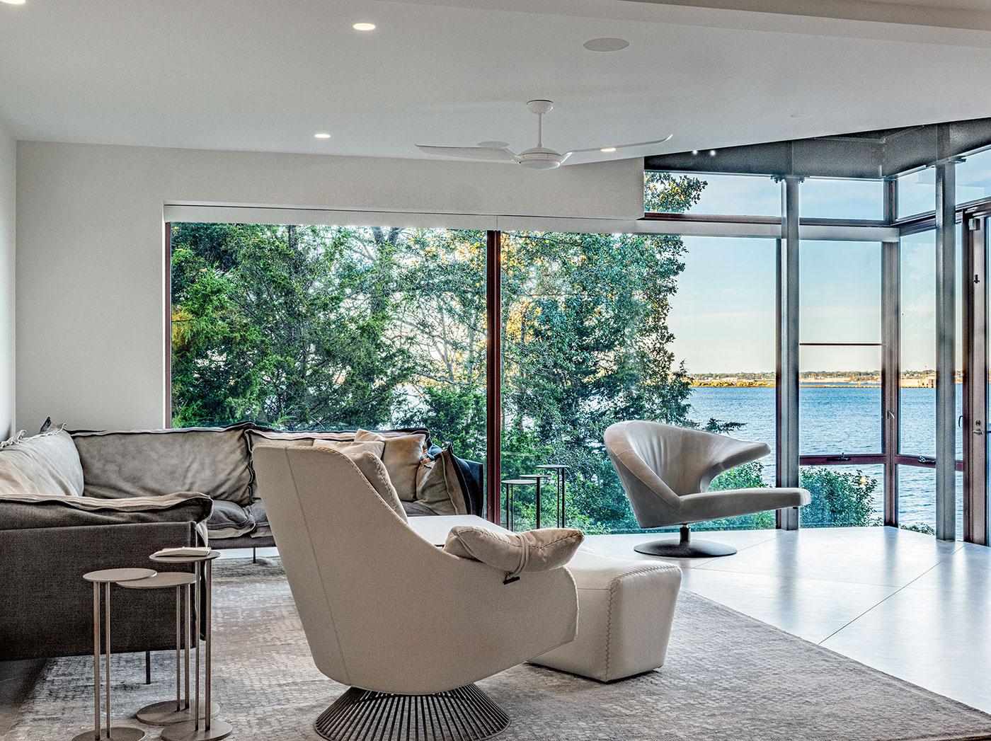 Modern living room with panoramic coastal views by Divine Design Center